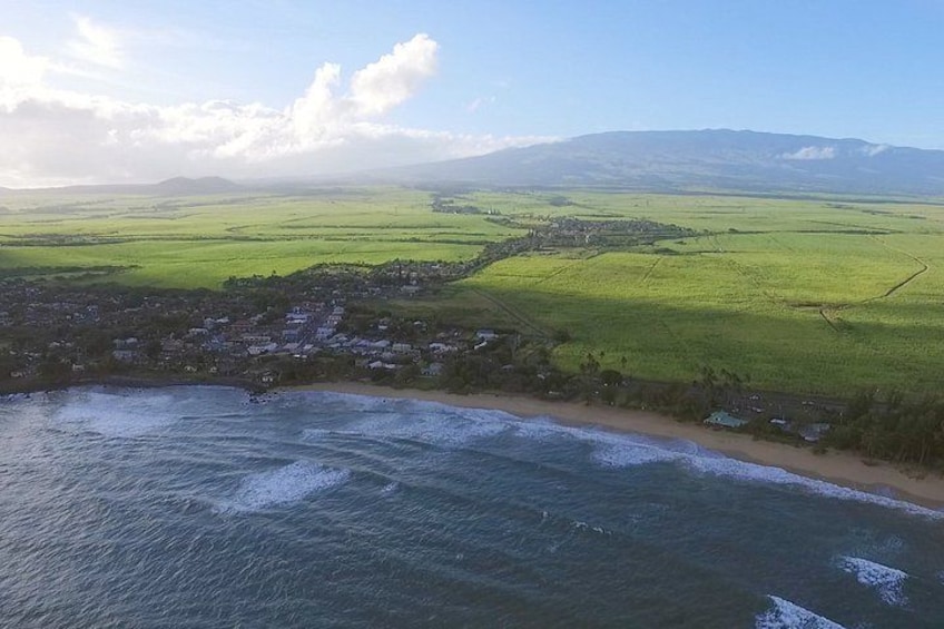 A coastal landscape with a beach, ocean, and a town in the distance. 3