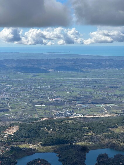 A landscape with a large body of water, a forested area, and a distant island. 5