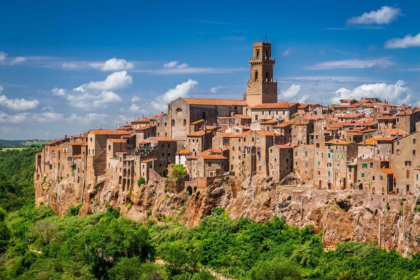 A historic town built on a cliff with a prominent tower. 1