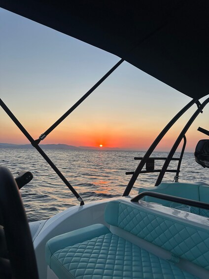 A boat's interior with a view of the sunset over the water. 1