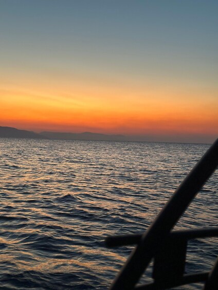 A sunset over a body of water with waves reflecting the colors of the sky. 3