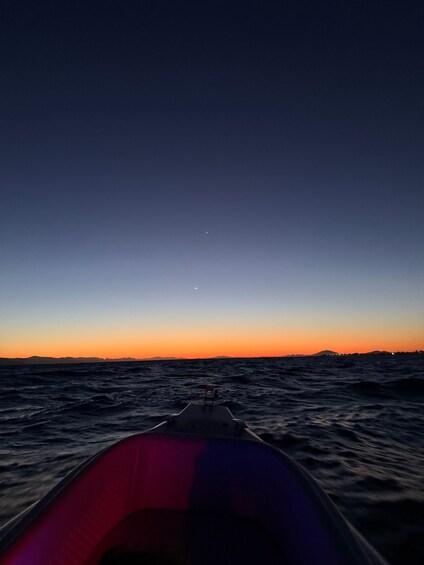 A boat on the water with a sunset in the background. 2
