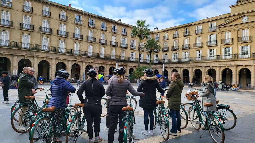 A group of cyclists in a courtyard with classical architecture. 5