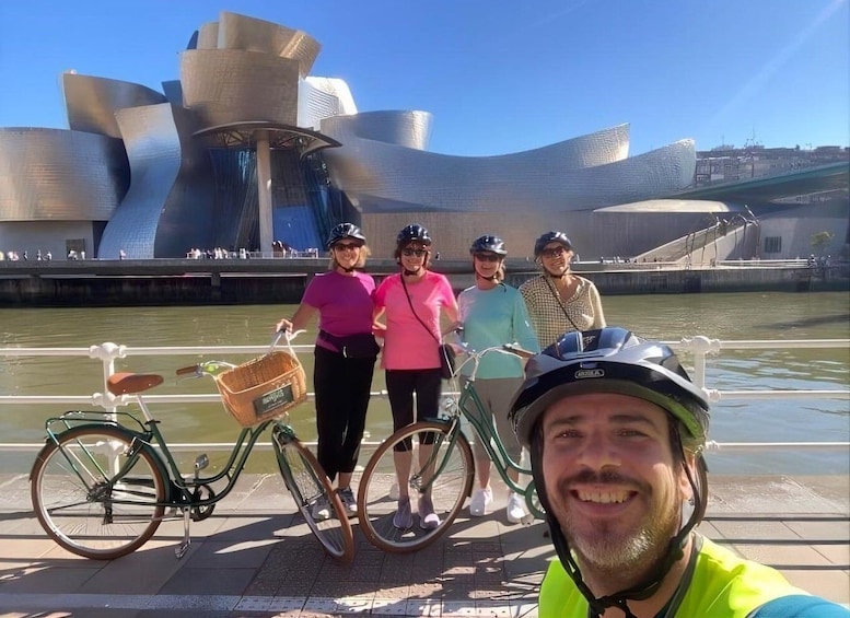 A group of people with bicycles in front of the Guggenheim Museum Bilbao. 1