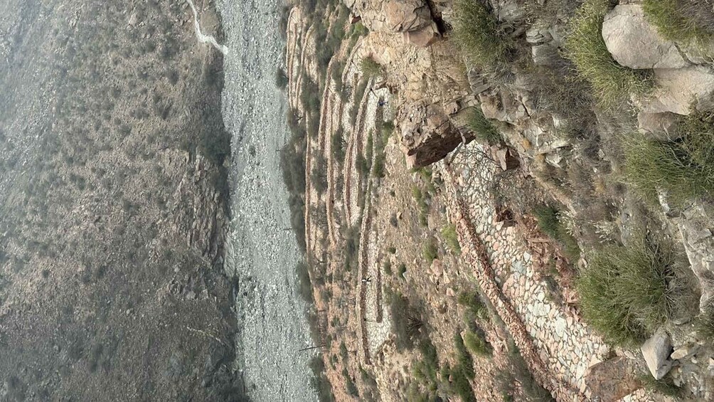 A rocky coastline with stratified layers and sparse vegetation. 2