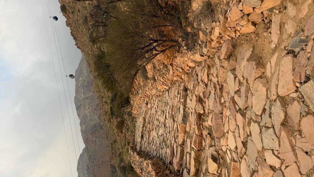 A rocky cliff with a helicopter in the background. 5