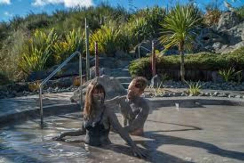 Two people in a natural pool with tropical vegetation and rocks. 2