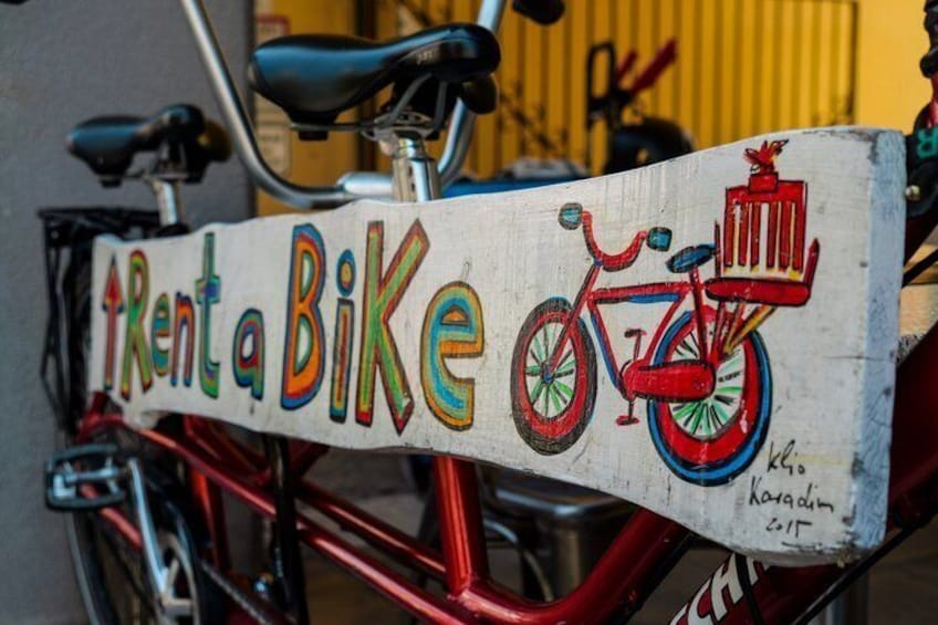 A red bicycle with a 'Rent a Bike' sign attached to it. 3