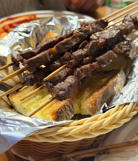 Skewered meat on bread in a basket. 2