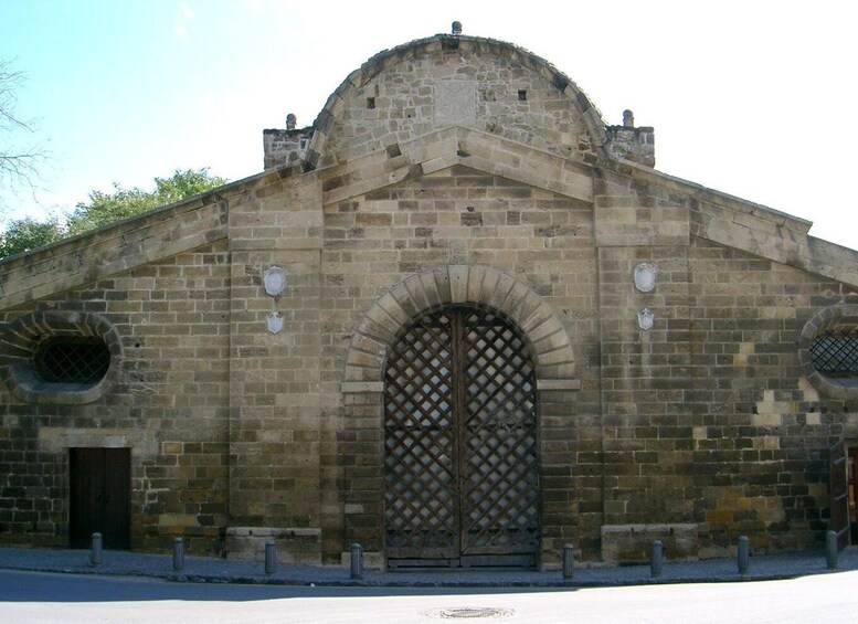 A stone building with a large arched entrance and a dome on top. 2