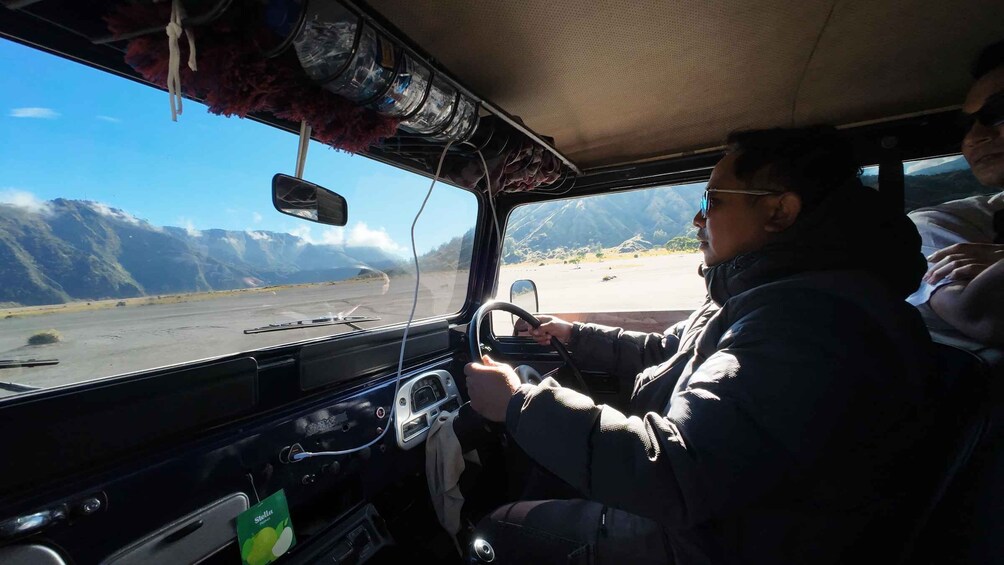 A vehicle driving through a mountainous area with a clear sky. 3