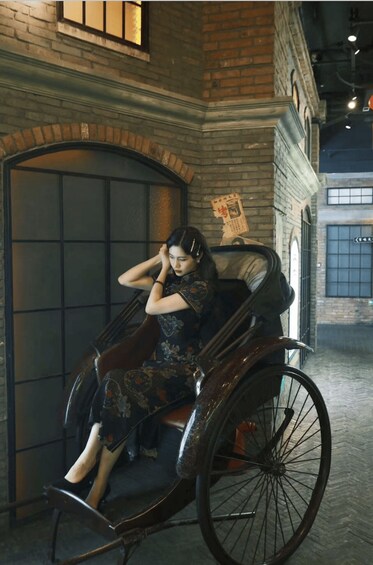 A person in a traditional carriage in an indoor setting with brick walls and a large window. 2