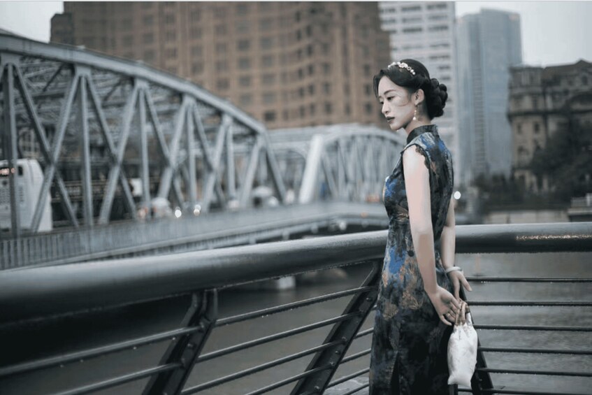 A person standing on a bridge with a cityscape in the background. 1