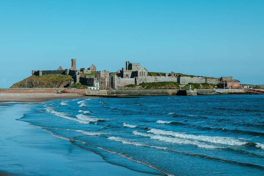 A coastal castle with a beach in the foreground. 1