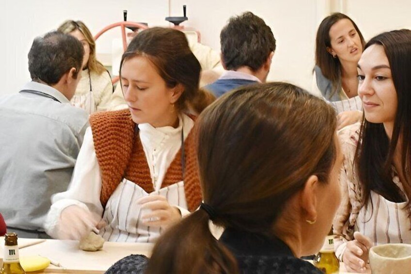 A group of people engaged in a cooking activity, with a focus on a person chopping vegetables. 4