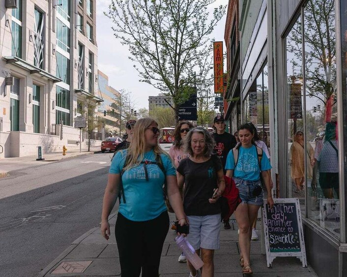 A group of people walking on a sidewalk, a building with a sign that reads 'CAMERON,' and a sign that says 'Mother and daughter chance to sparkle.' 5