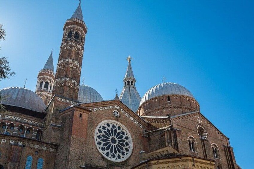 A historic building with a large rose window, multiple domes, and a tall tower. 2