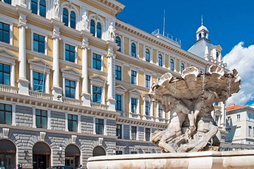 A classical building with a large fountain in front. 1