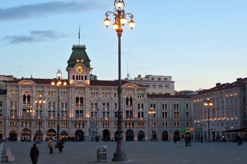 A historic building with ornate architecture, a large open plaza, and a street lamp. 2