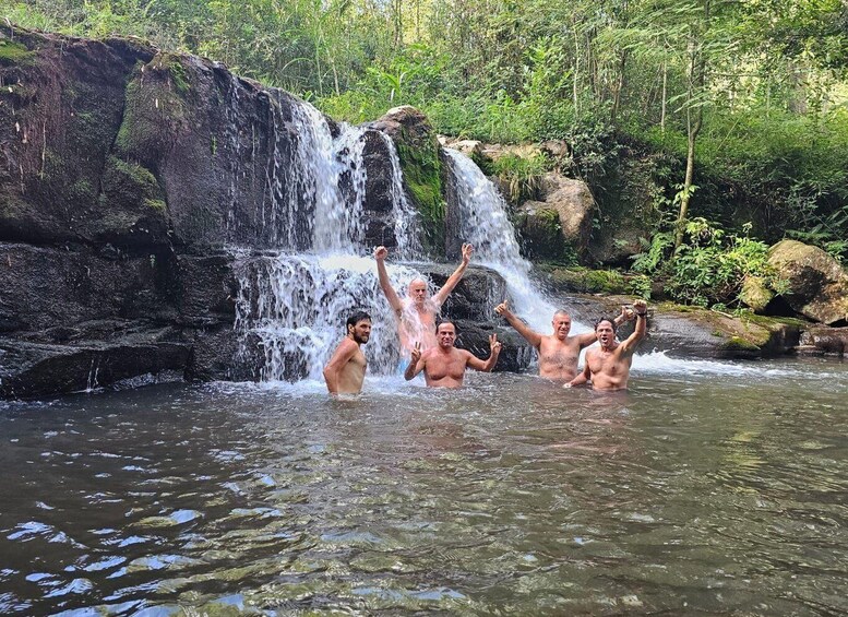 A waterfall with people jumping in the water below. 1