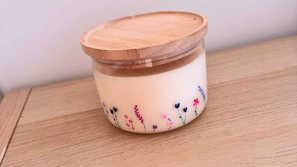 A ceramic jar with a wooden lid and floral designs. 3