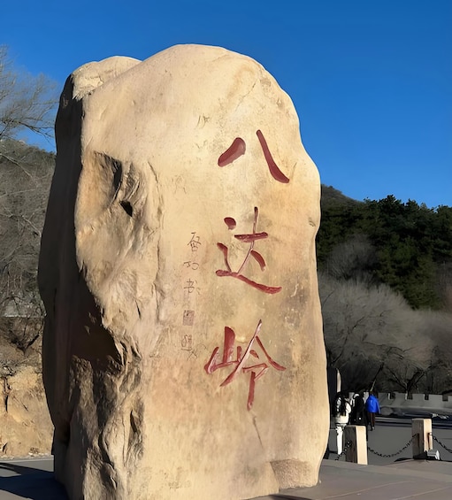 A large rock with carved Chinese characters and a plaque. 5