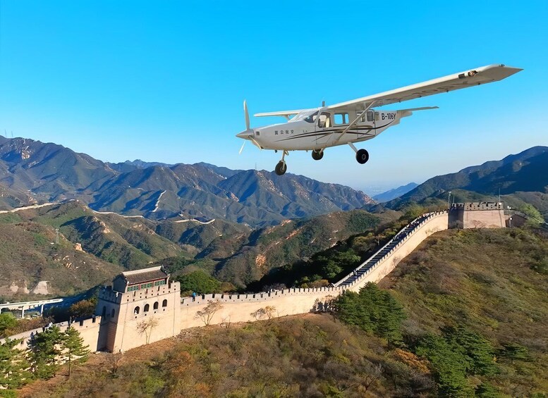 A small aircraft flying over the Great Wall of China. 1