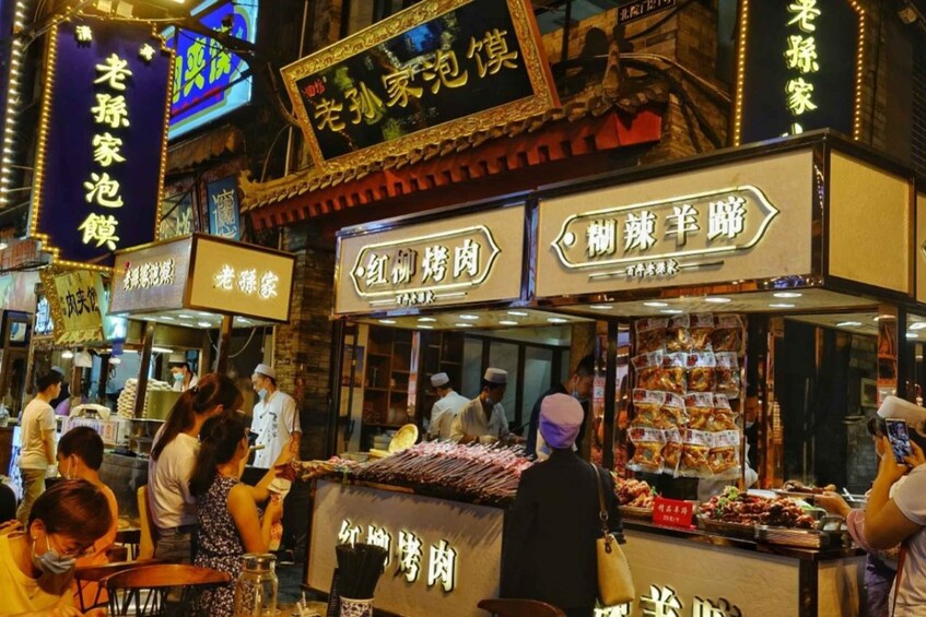 A bustling street food market with various stalls selling traditional snacks and meats. 4