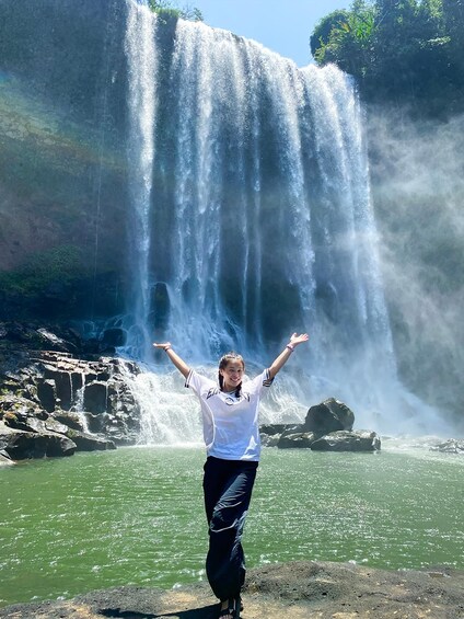 A waterfall with a person standing in front of it. 1