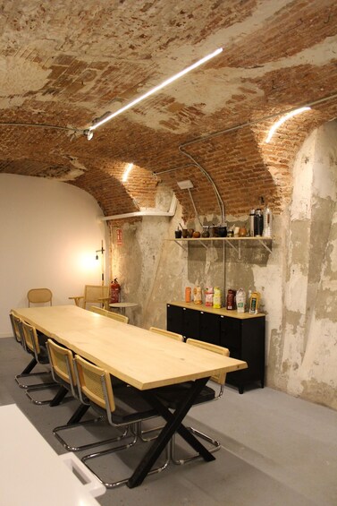 A conference room with a long table, chairs, a whiteboard, and a brick wall. 2