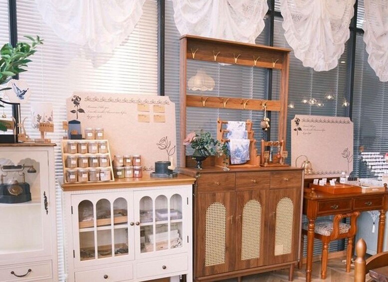 A vintage-style shop with wooden furniture, glass display cabinets, and lace curtains. 3