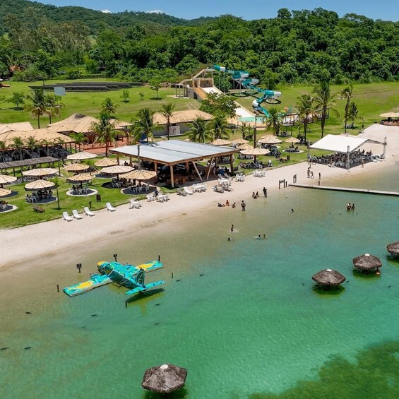 A beach resort with clear waters, palm trees, and a water park. 1