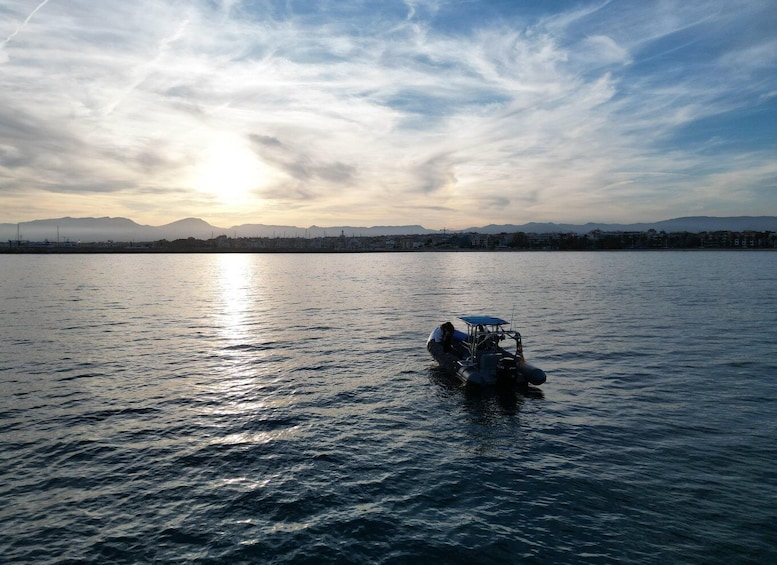 A boat on calm water with a sunset in the background. 3