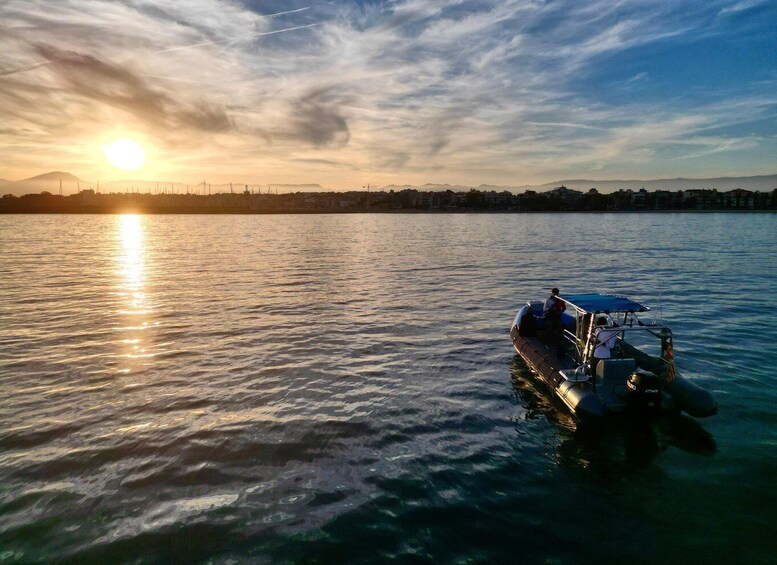 A boat on calm water with a sunset in the background. 4