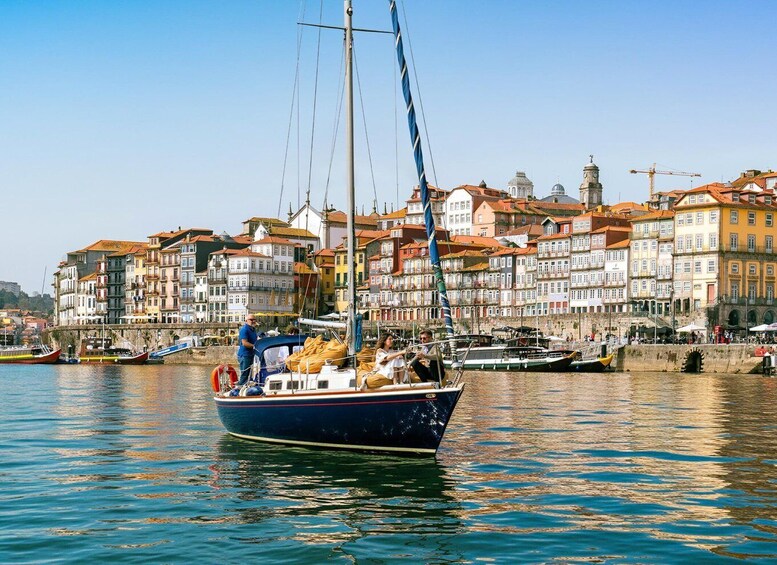 A sailboat docked at a harbor with colorful buildings in the background. 5