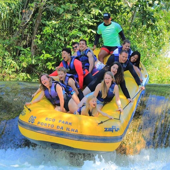 A group of people in a yellow raft labeled 'ECO PARK PORTO DA ILHA' navigating a water slide. 3