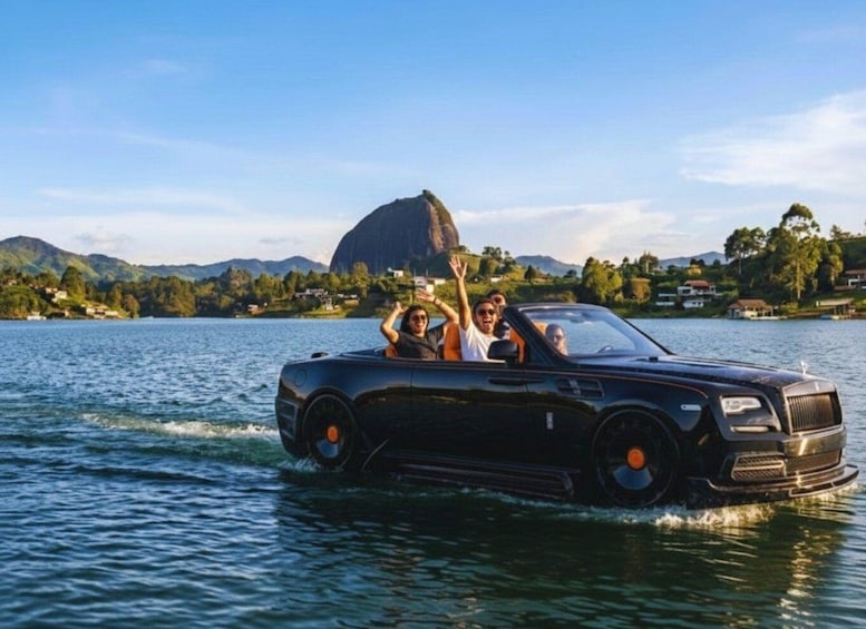 A black convertible car driving on water with people in the backseat. 4