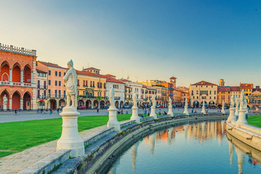 A historic square with a fountain, statues, and colorful buildings. 3