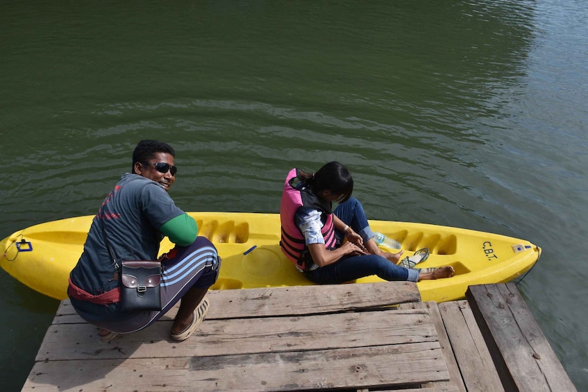 Two people in a yellow canoe on a wooden dock by a body of water. 3