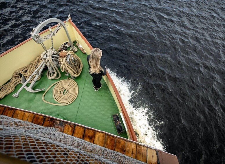 A boat deck with ropes, an anchor, and a person standing. 2