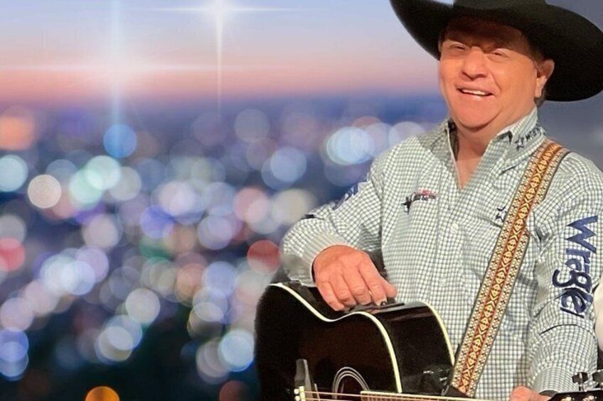 A person playing a guitar with a cityscape in the background. 1