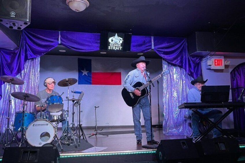 A band performing on stage with a Texas flag backdrop. 5