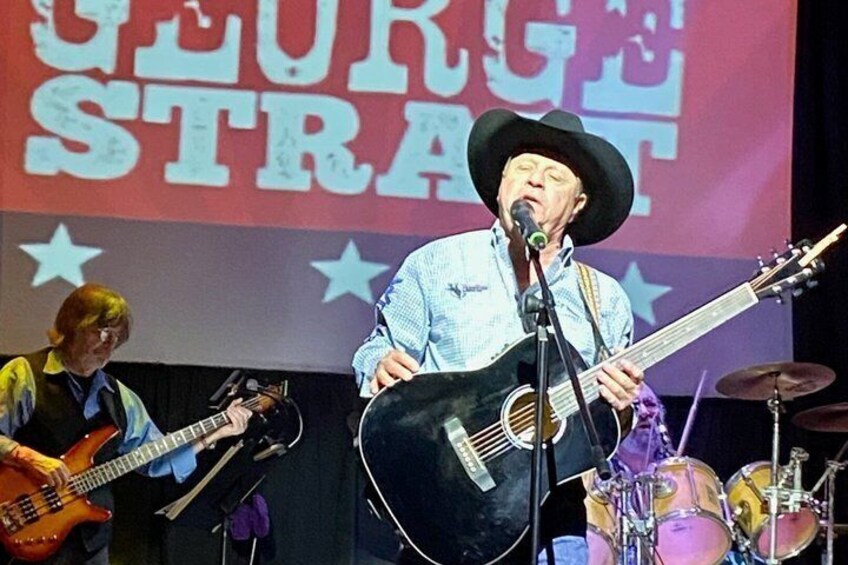 A man performing with a guitar on stage, a drum set, and a backdrop with 'GEORGE STRAIT' text. 4