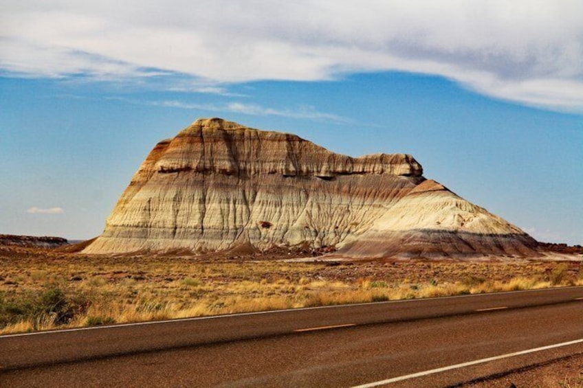 A large rock formation with a road in the foreground. 2