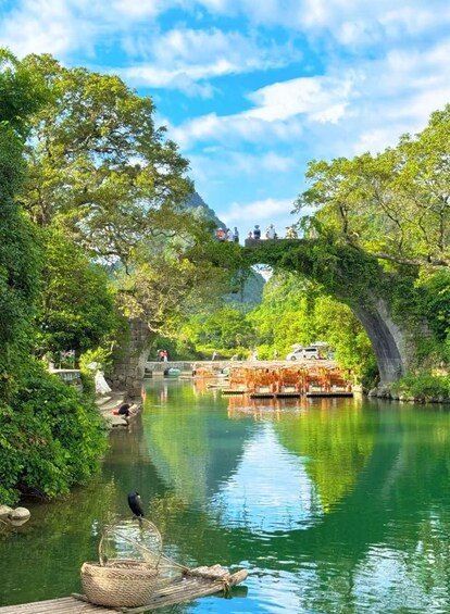 A river with a wooden bridge, lush greenery, and a clear sky. 4
