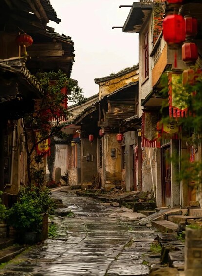 A narrow alley with traditional buildings, red lanterns, and stone paving. 3