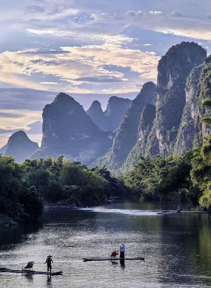 A calm river with people paddling canoes, surrounded by lush greenery and towering limestone cliffs. 5