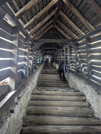 A covered wooden staircase with metal railings, leading to a higher level. 4