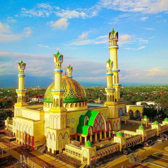 Une grande mosquée dotée de deux minarets, d’un dôme vert et d’une cour. 1