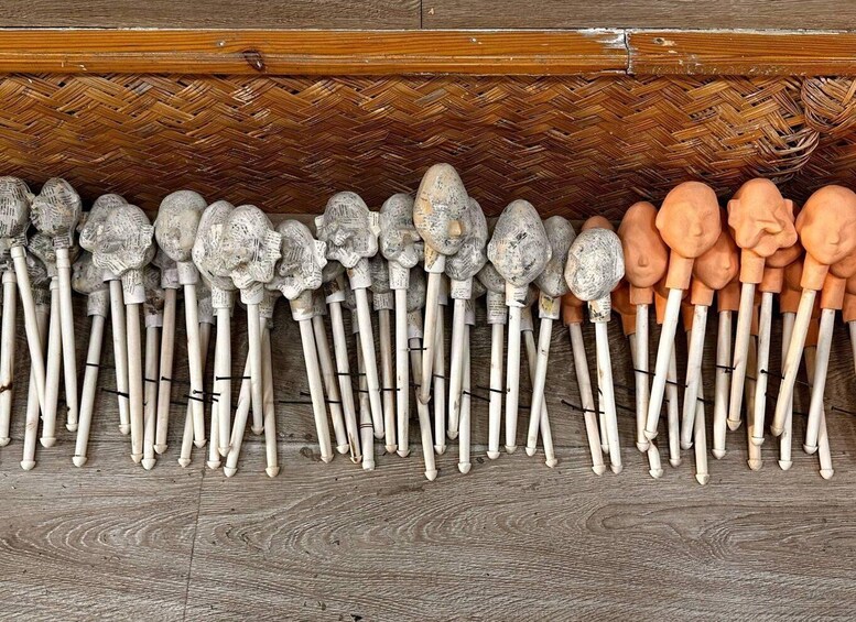 A collection of wooden walking sticks lined up on a wooden floor. 3